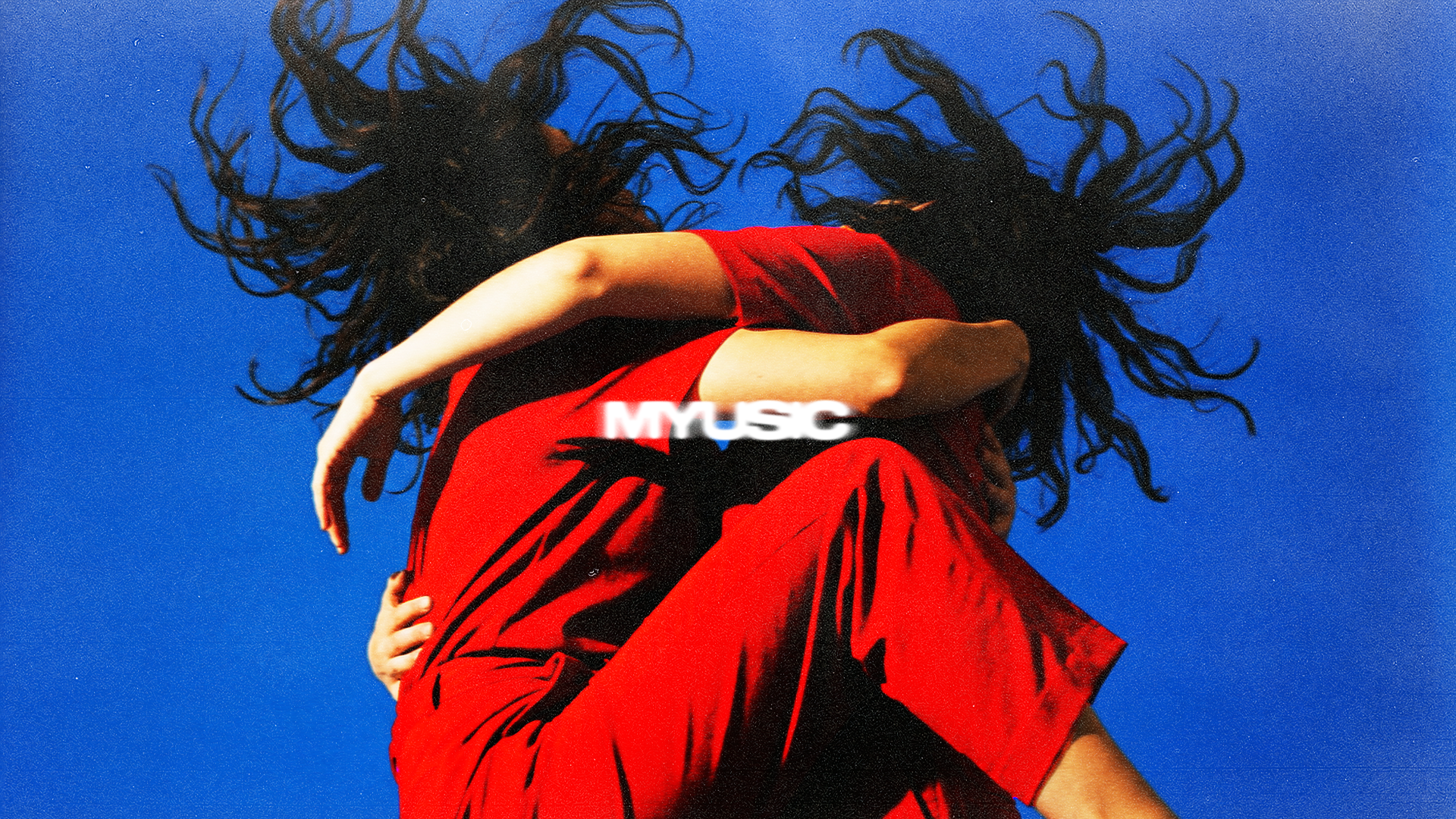 Girl in red dress with hair flying against electric blue background
